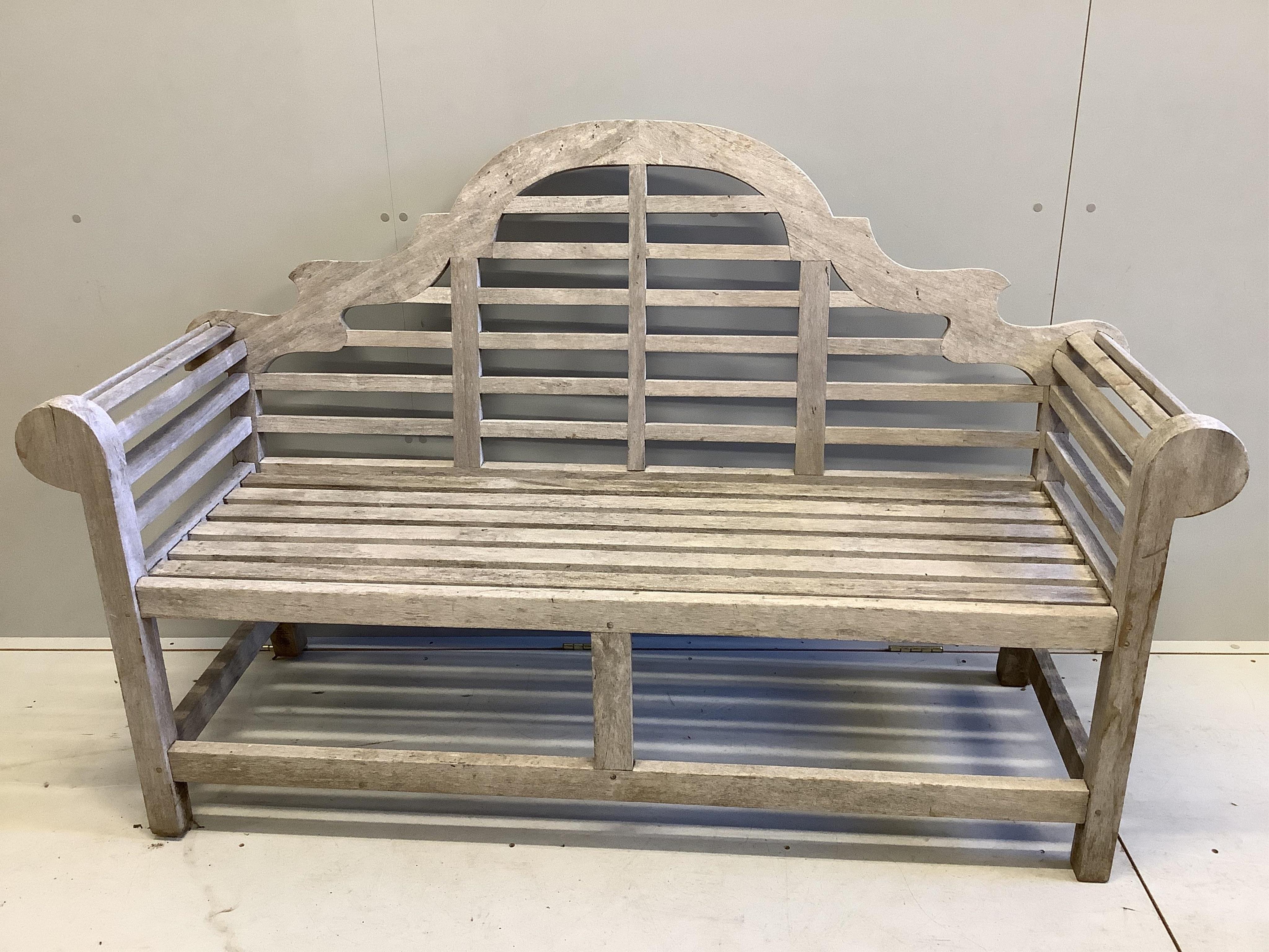 A Lutyens style teak garden bench, width 166cm, and a matching side table, 80cm. Condition - both weathered otherwise good